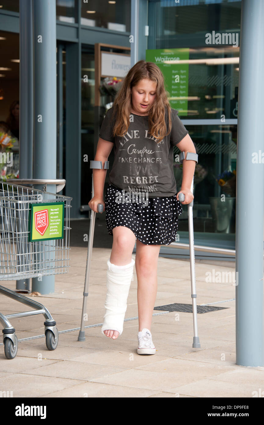 Young girl on crutches with broken leg in plaster FULLY
